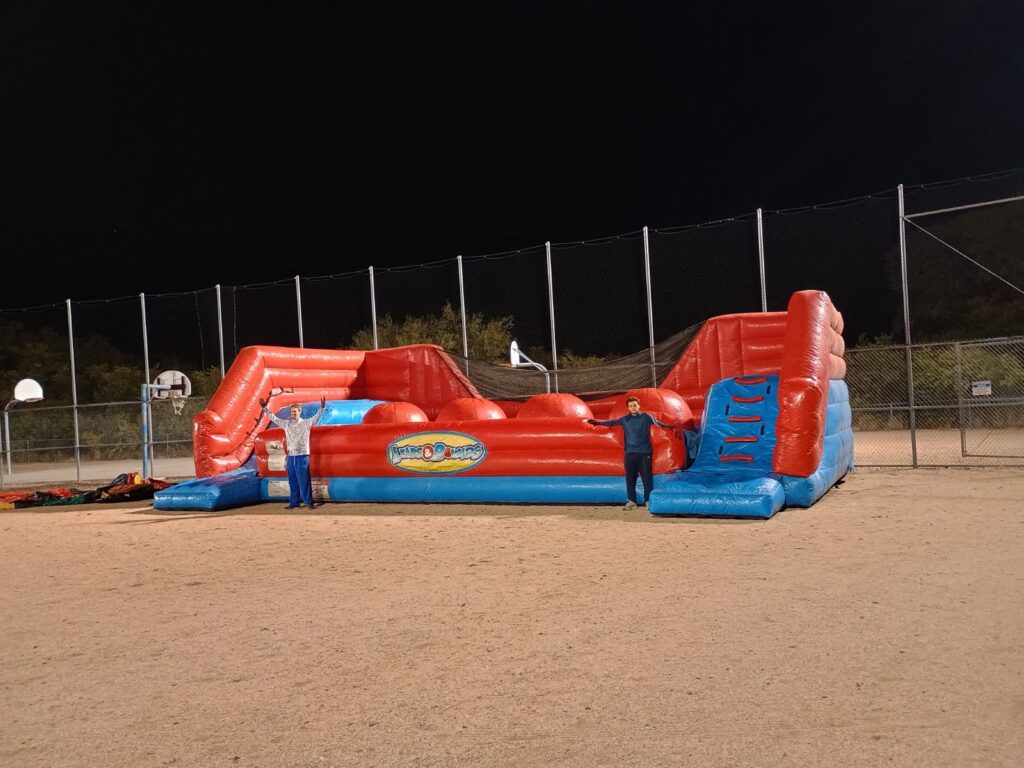 Big Red Ball Wipeout inflatable game rental for school events, carnivals, and parties in Phoenix, Buckeye, Chandler, Queen Creek, and Litchfield Park — fun obstacle challenge seen on popular TV shows.